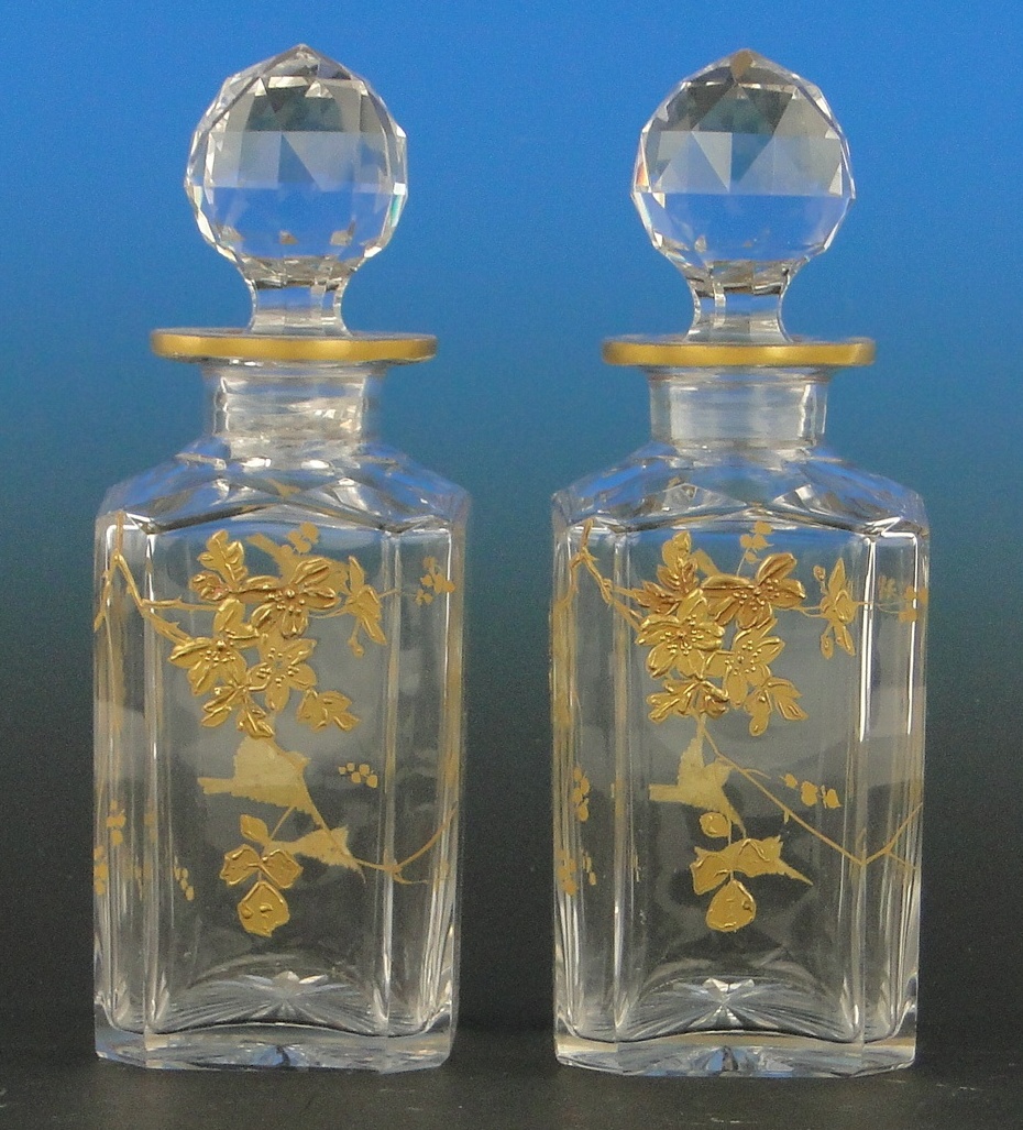 A pair of Baccarat gilded cutglass decanters and stoppers, with bird