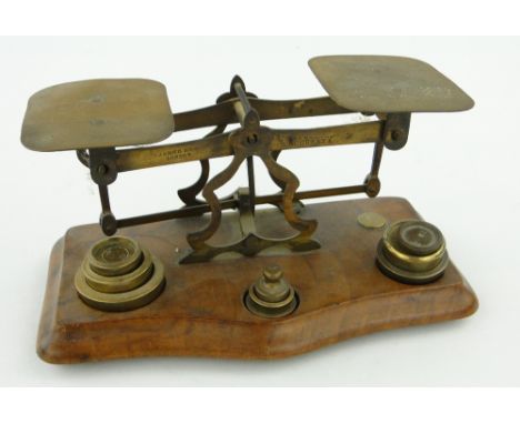 A brass postal letter scales
and weights, on walnut stand, 6.75" across.