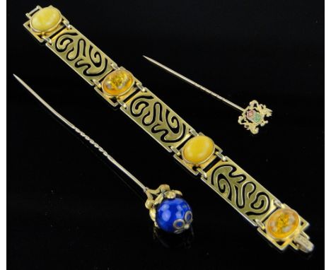 A Victorian gold and enamel topped stickpin,
a Carringtons 9ct gold stickpin and an amber set costume bracelet, (3).