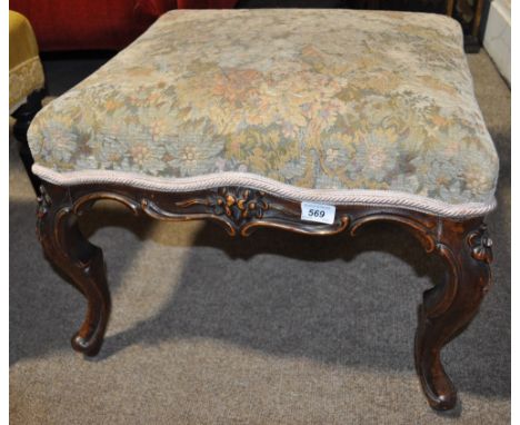 A Victorian upholstered dressing stool,
having a floral carved oak frieze and cabriole legs, width 20", height 15".