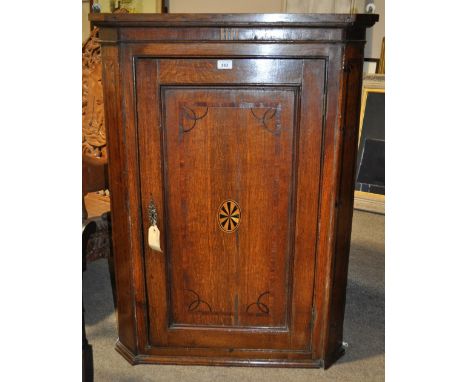 A Georgian oak hanging corner cupboard, 
with single panel door and inlaid decoration, width 2'6, height 3'4.5.