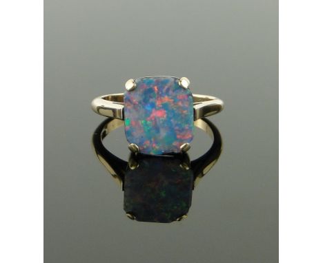 A black opal doublet panel ring,
9ct gold settings, panel height 11mm, size N.