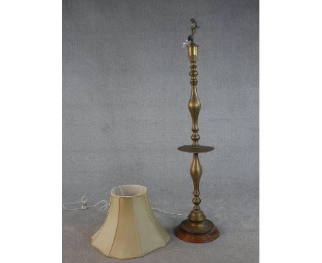 A 20th century turned brass standard lamp, on a circular base with a turned wood foot. H.164cm 