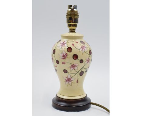 Moorcroft lamp in the Tembusu pattern mounted onto wooden base, 27cm tall inc fittings.  In good condition with no obvious da