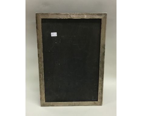 A massive silver engine turned picture frame. London. Approx. 33 cms x 22 cms. Est. £50 - £80.