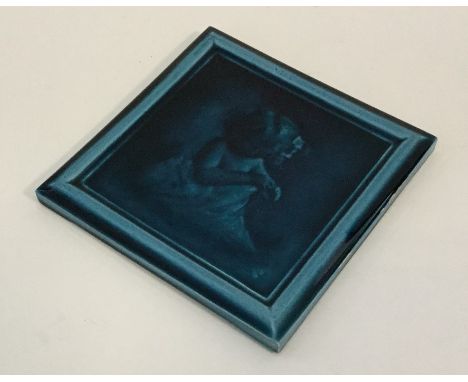 A 19th Century Leeds Pottery Burmantofts Faience blue glazed tile depicting a small child in a blanket. Marked 'H1' to revers