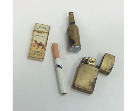 A novelty cigarette lighter in the form of a bottle together with three others. Est. £15 - £20.