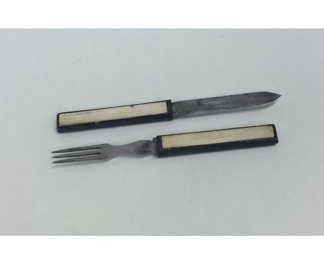 An unusual Antique carved ivory travelling knife and fork. Approx. 57 grams. Est. £80 - £120.