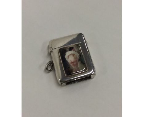 A hinged top silver vesta case with enamel decoration depicting a lady raising her skirts. Birmingham 1903. Approx. 36 grams.