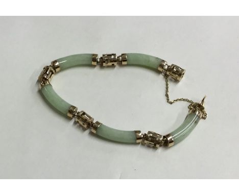A 14 carat jade bracelet with concealed clasp and safety chain. Approx. 17 grams. Est. £150 - £200.
