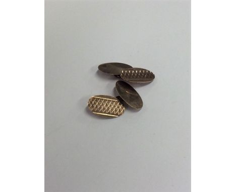 A pair of oval 9 carat engine turned cufflinks. Approx. 3.8 grams. Est. £30 - £40.