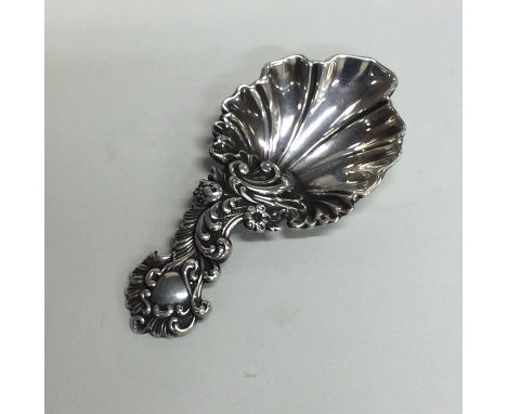 A good scroll and floral decorated cast silver caddy spoon. London. By AH. Approx. 15 grams. Est. £100 - £150.