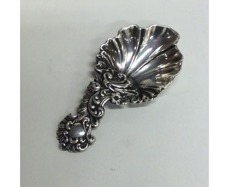 A good scroll and floral decorated cast silver caddy spoon. London. By AH. Approx. 15 grams. Est. £100 - £150.