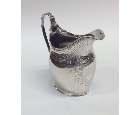 A Georgian silver helmet shaped cream jug with crested front and reeded border. London. Approx. 109 grams. Est. £60 - £80.