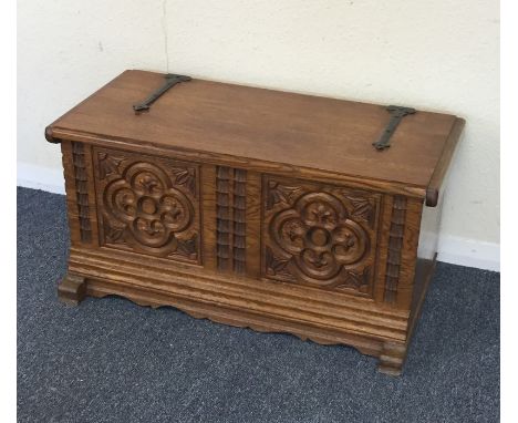 A small oak carved hinged top trunk. Est. £25 - £35.