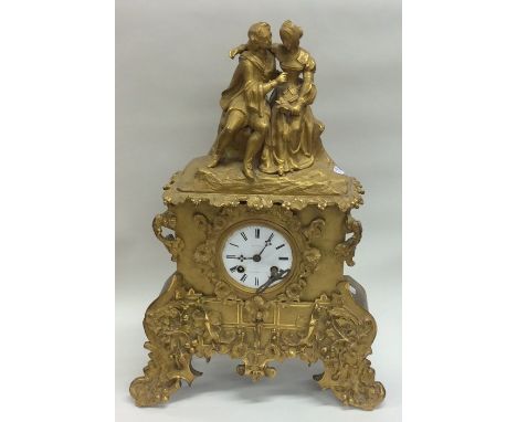 A French brass mantle clock with white enamel dial mounted with a romantic scene to top. Est. £100 - £150.