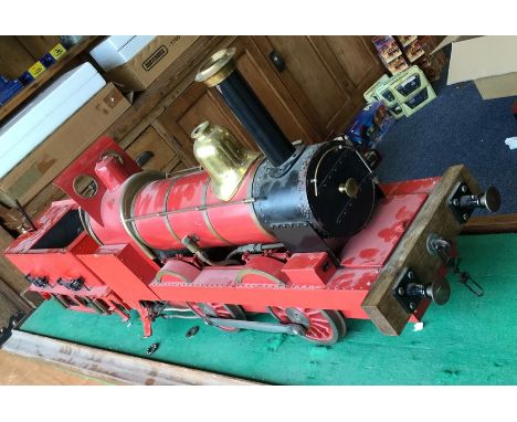 A good 5 inch gauge model of a steam engine and tender in red on wooden stand. Est. £1500 - £2000.