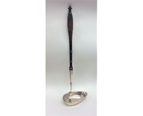 A large Antique Russian silver ladle with pouring lip and turned wooden handle. Approx. 145 grams. Est. £300 - £400.