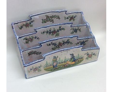 A French Quimper letter rack with blue ground decoration. Est. £30 - £50.