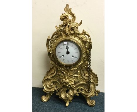 A massive reproduction brass mantle clock with white enamel dial. Approx. 55 cms high. Est. £80 - £120.