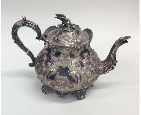 A Britannia Metal teapot embossed with flowers adn scrolls together with a plated decanter stand. Est. £20 - £30.