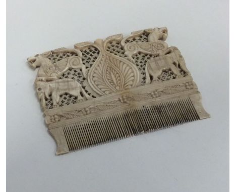 An Antique carved ivory comb decorated with dogs. Est. £30 - £50.