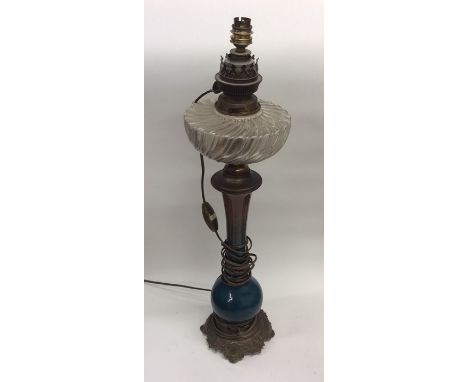 A Continental brass mounted oil lamp with glass reservoir. Est. £30 - £50.
