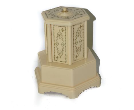 Selcol vintage plastic musical cigarette box with press button to top above six revolving doors. 19cm high