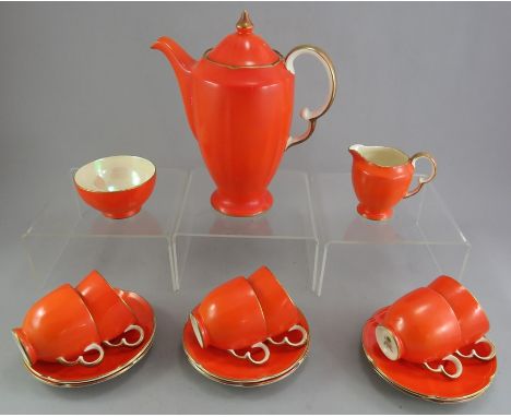 A Crown Devon coffee service decorated in an orange ground with gilded edges: coffeepot, sugar, creamer and six cups and sauc