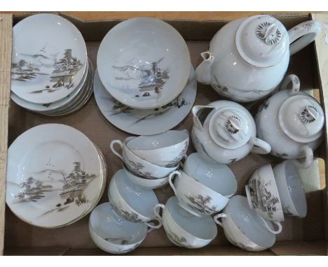 A Japanese ceramic tea service decorated with island scenes. To include: 12 saucers, 12 side plates, 2 plates, 11 cups, 1 tea