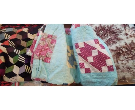 A late 1930s early 1940s turquoise background quilt with squares of assorted colourways of patchwork squares, one edge has so