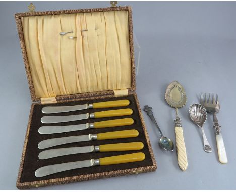 A silver caddy spoon, a silver fruit fork with mother of pearl handle, a Rolex spoon and a set of cased knives. Some wear. 