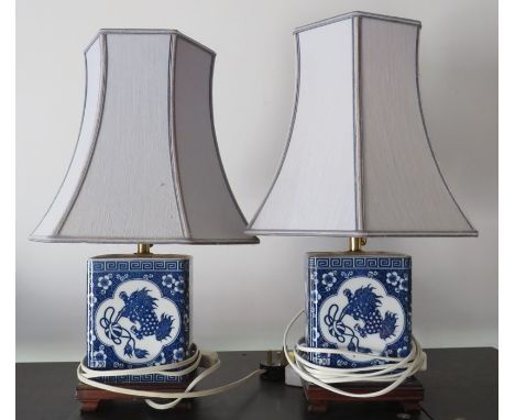 A pair of modern ceramic table lamps with shades decorated in blue and white in the Chinese style. (2)