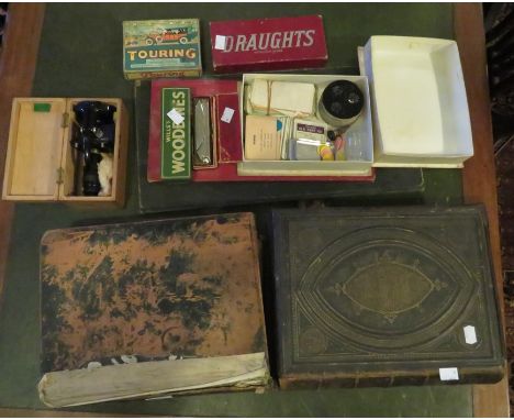 Two bibles, a boxed microscope, playing cards, draughts, a harmonica and two playing boards.&nbsp;