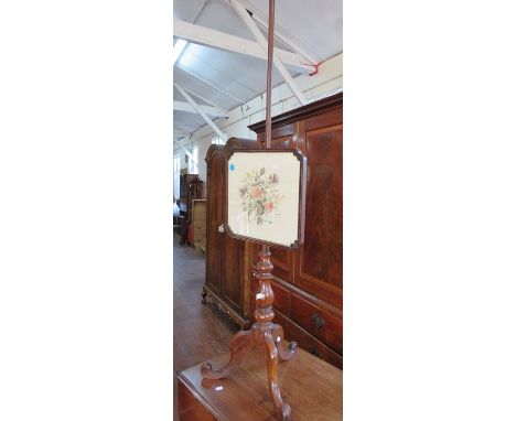 A Victorian mahogany adjustable fire screen on pole with needlework panel. 147cm tall.&nbsp;