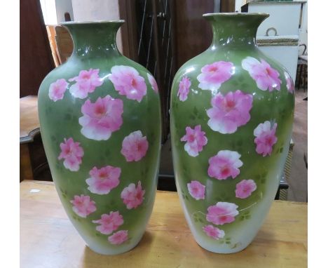 A pair of decorative ceramic vases with floral decoration. 44 cm tall. (2) One damaged and stuck. 