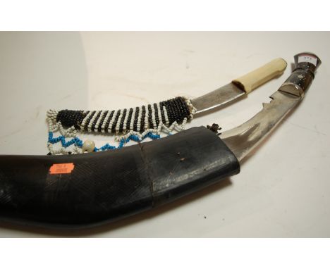 An Eastern kukri in leather scabbard; together with a Far Eastern janbiya (2)