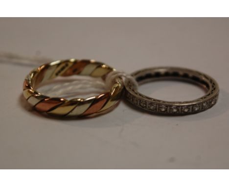 A white metal (probably platinum) diamond set eternity ring, and one other 9ct three colour gold band ring (2)