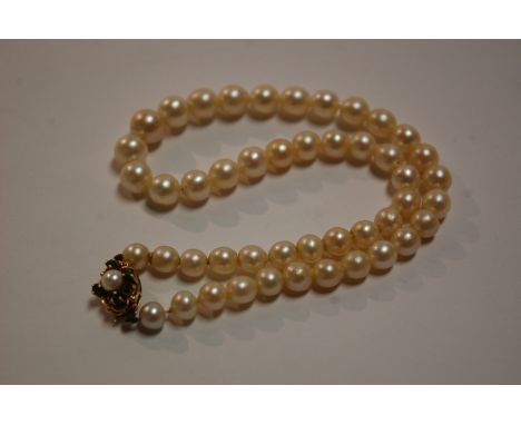 A cultured pearl single string necklace having 9ct gold and emerald set clasp