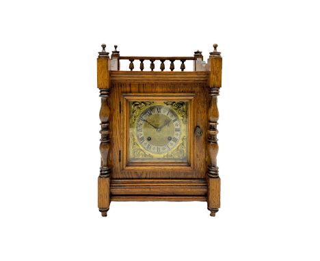 An early 20th century oak cased mantle clock in the arts and crafts style, case decorated with a rear balustrade, turned fini