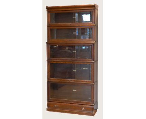 An oak Globe Wernicke library bookcase, the five graduated glazed sections over a single drawer base section, on a plinth bas