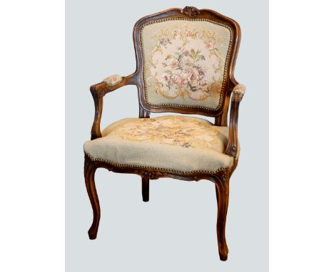 A French Louis XVI style armchair, having carved walnut frame, tapestry upholstered, standing on scroll cabriole legs.Width 6