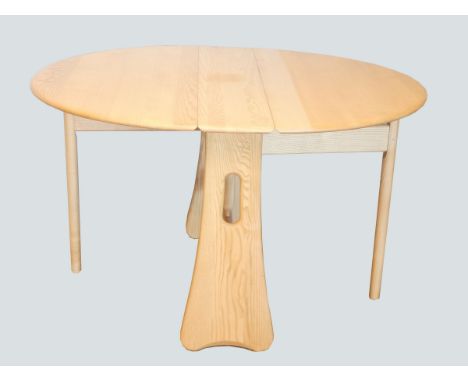 A bleached oak Ercol drop-leaf dining table, having gate-leg action.122 x 106cm extended. 