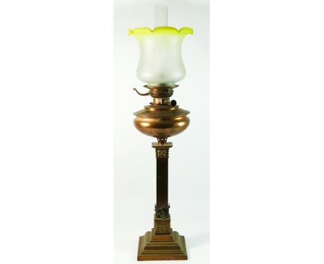 An early 20th century brass and copper oil lamp, having frosted glass tulip shade with copper bowl, standing on a stepped col