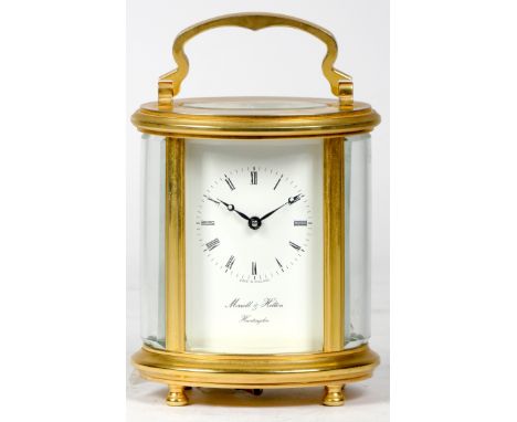An English carriage clock of oval form, the white enamelled dial with Roman numerals and inscribed Morrell & Hilton, Huntingd