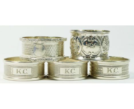 A set of three silver napkin rings, Birmingham 1947, engine turned decoration, initialled KC, and two other silver napkin rin