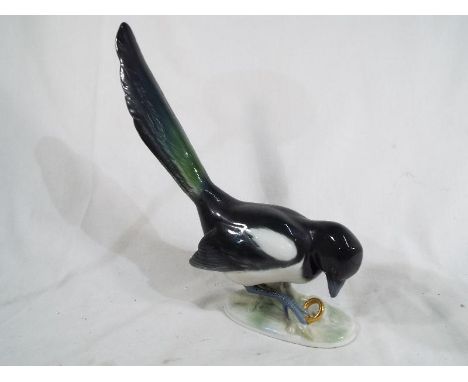 Metzler and Ortloff - a German figurine depicting a magpie with gold ring, model no 7548, 25 cm 