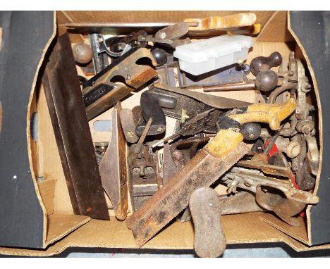 A box containing vintage and modern tools, vintage wooden plan and saws, modern socket set, metal wood plane and staple gun