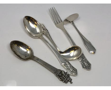 A highly ornate silver spoon and a four piece christening set depicting scenes from folklore signed, Art Krupp Binsdorf.