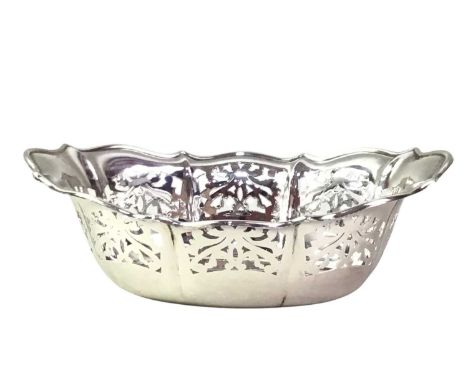 TWO SILVER BON BON DISHES, ALONG WITH A SUGAR CASTER AND CANDLESTICK  the bon bon dishes of shaped oval form, also including 
